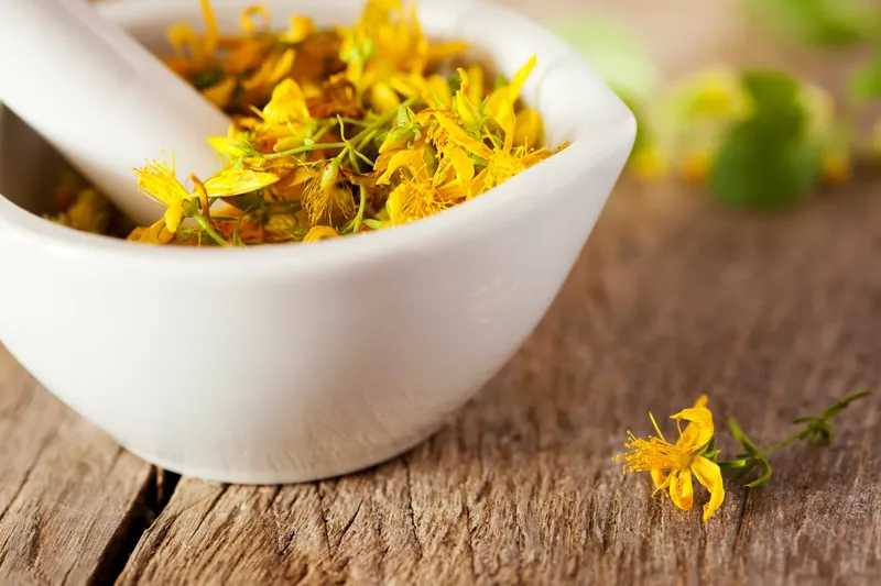 Yellow flowers in a white mortar with pestle