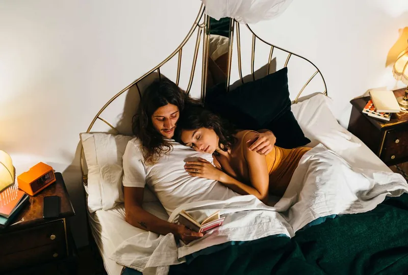 Young couple reading at bed before sleeping.