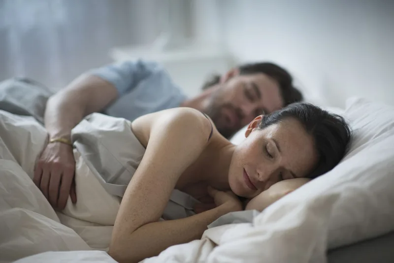 Couple sleeping together in bed at night