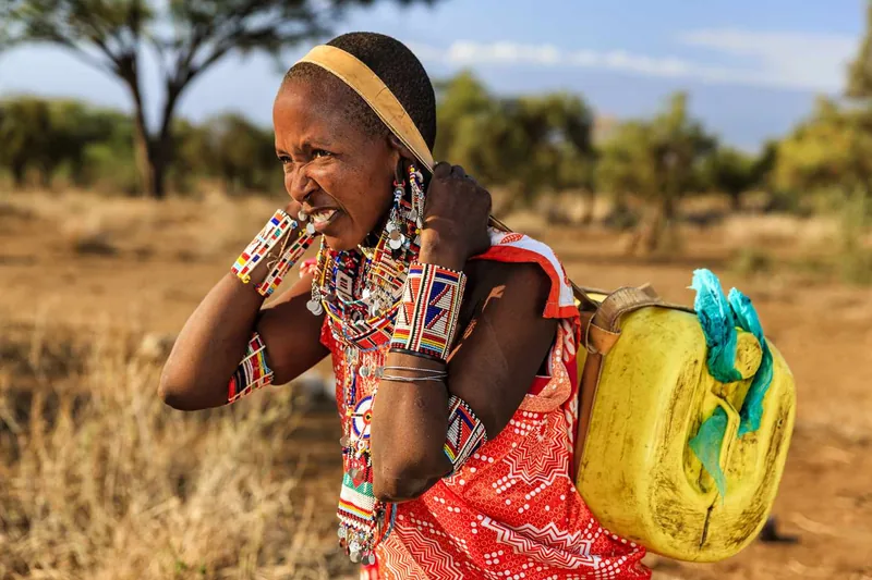 African woman from Maasai tribe carrying water to their village