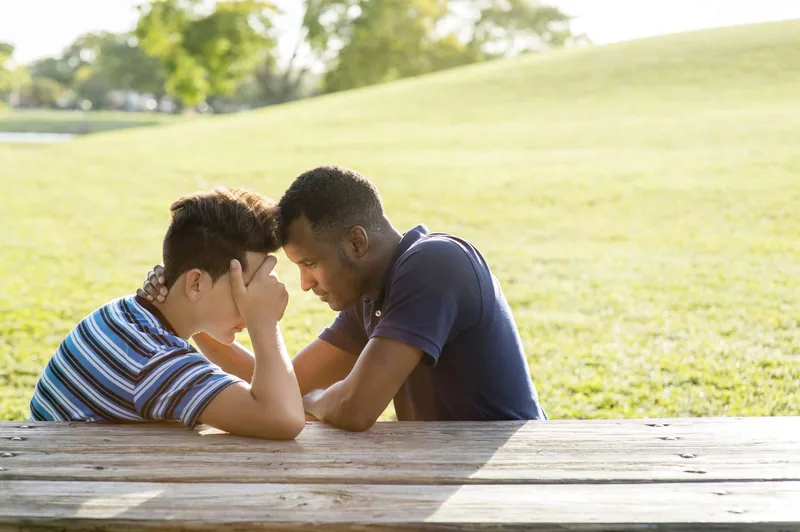Father and son talking in park