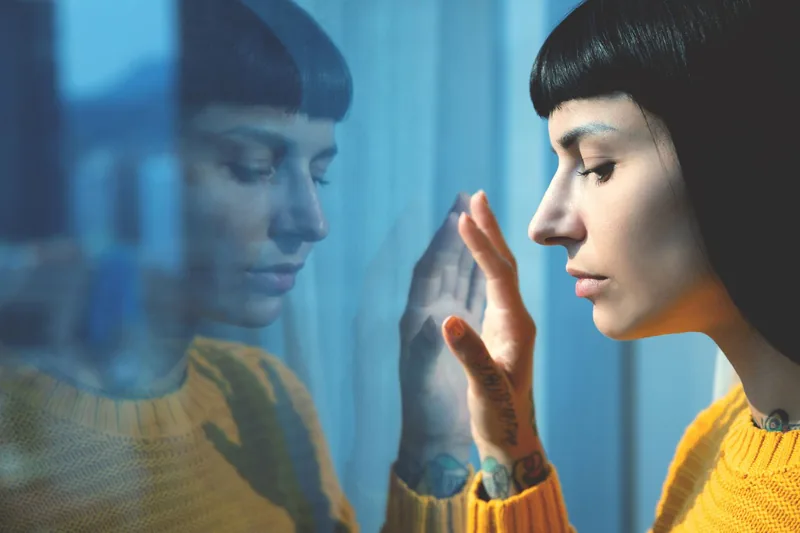 A person looking distressed and confused, with fragmented reality depicted around them through distorted visuals.