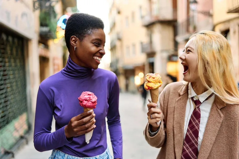 Two friends smiling eating ice cream in Barcelona