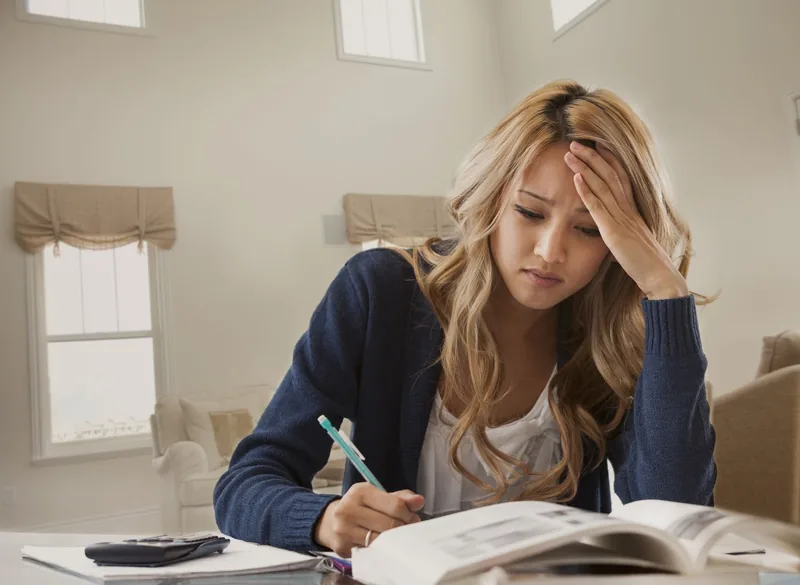 Anxious mixed race woman studying