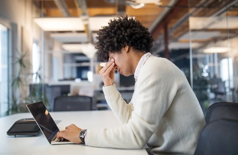 Man working late at his computer feeling stressed