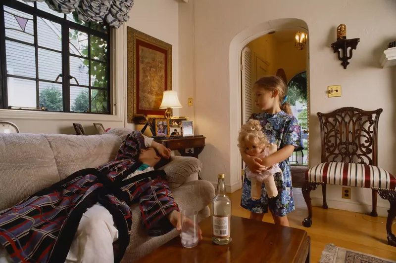 young Daughter Looking at drunk Mother on the couch