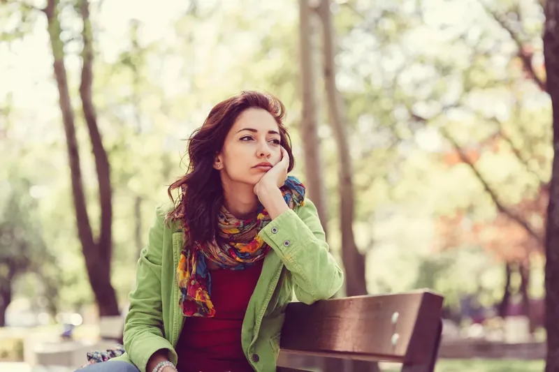 Unhappy woman sitting on a park bench