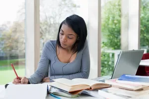 University student writing at desk