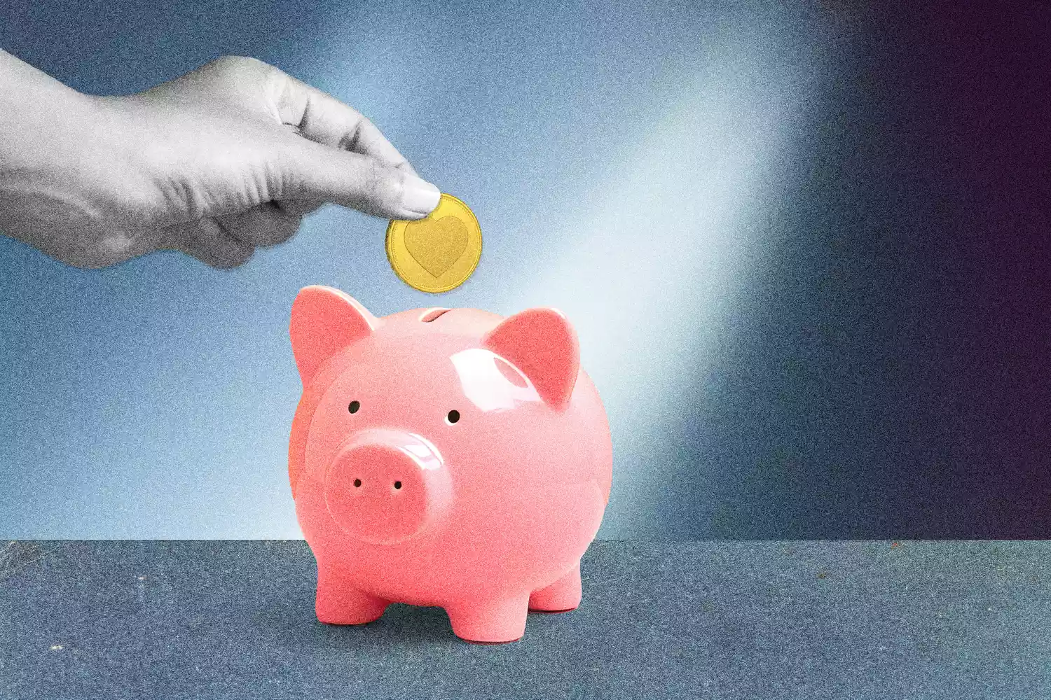 Hand dropping coin in piggy bank