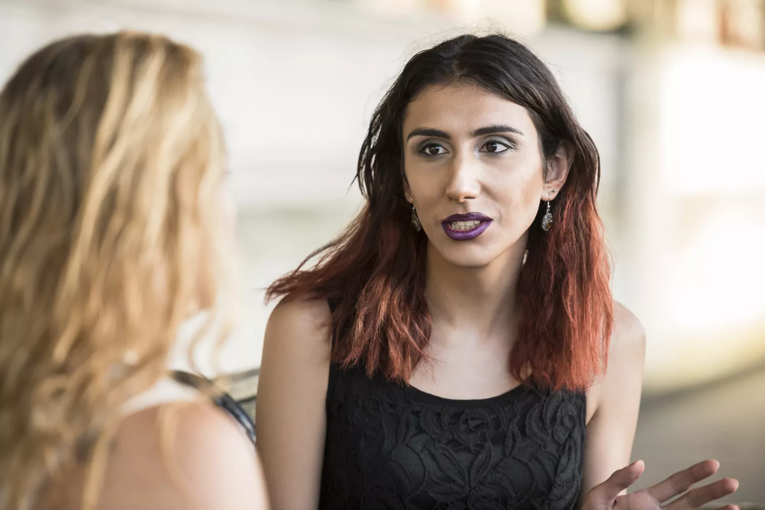 Two female transgender friends talking, candid portrait of friends having conversation