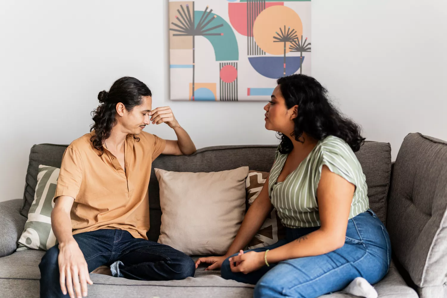 Young couple arguing in living room at home