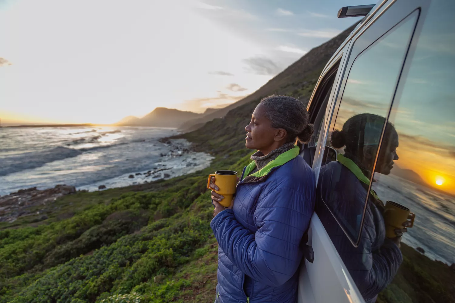 woman looking at a sunset by the sea