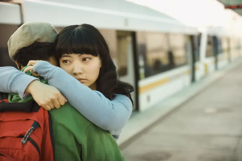 Couple hugging at a train station