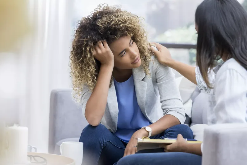 Depressed young woman talks to therapist