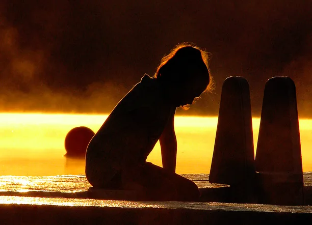 A person's hand, possibly holding another hand or an object, symbolizing support or endurance.