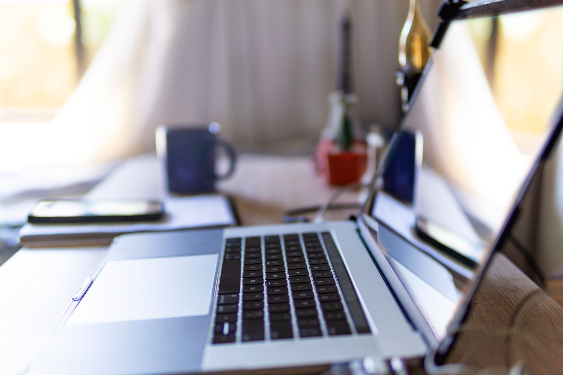 Bright home office scene with laptop, mug, and decor on a desk.